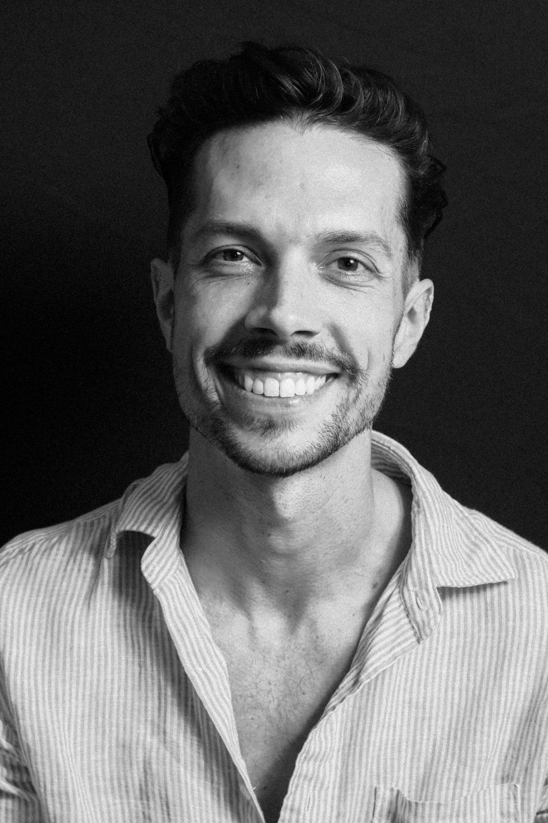 Mateo Danza smiling, photographed in black and white
